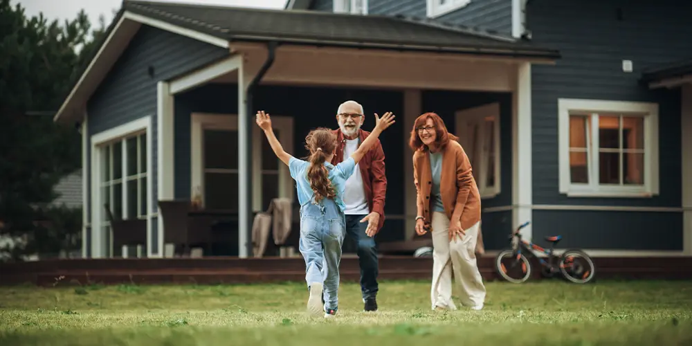 granddaughter running toward her grandparents in their yard indexed universal life insurance