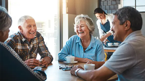 group of senior friends at restaurant together drinking coffee retirement income safe