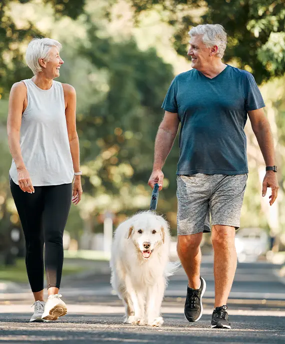 happy retirees walking their golden retriever retirement annuities