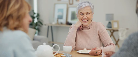 retired woman enjoying a cup of coffee with friends fixed indexed annuity