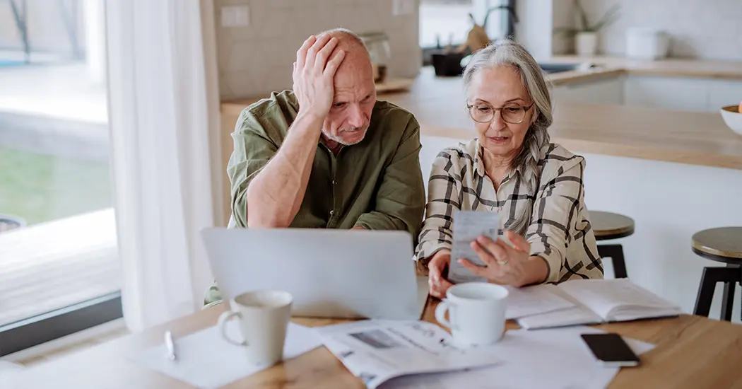 senior couple sitting at kitchen table reviewing retirement budget will i have enough to retire