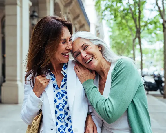 smiling senior friends embracing on walk outdoors retirement income safe
